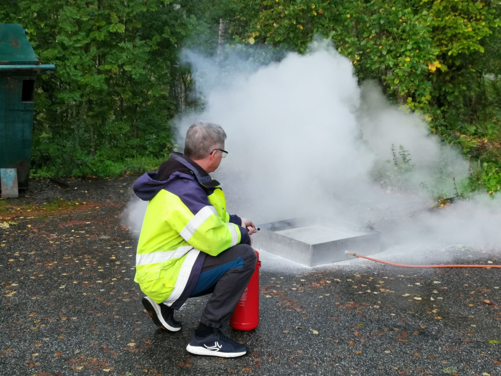 Instruktören visar hur man släcker en brand.