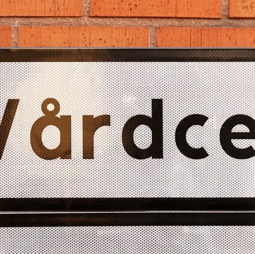 Skylt med texten "Vårdcentral" på tegelvägg. S-HLR.