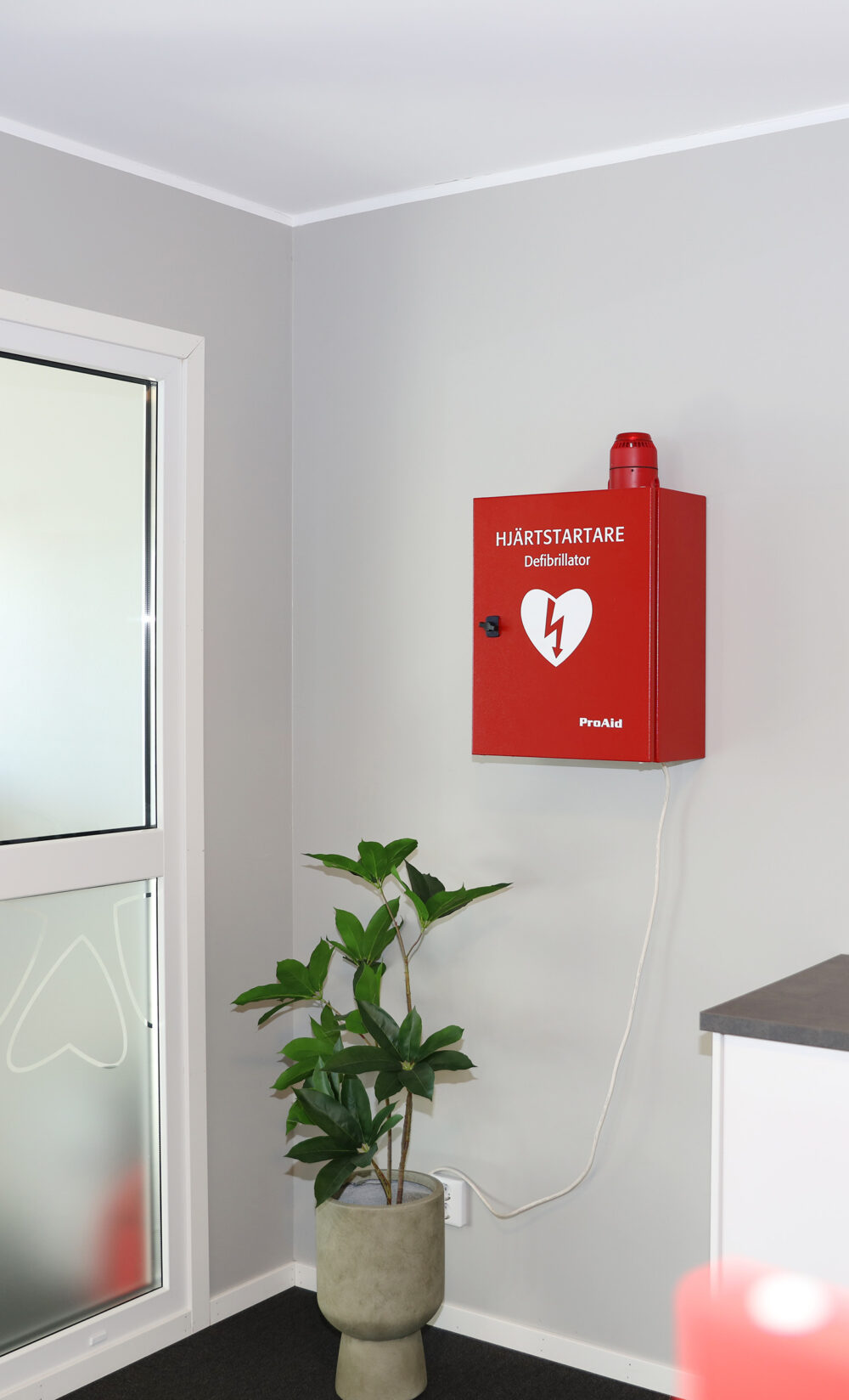 Hjärtstartarskåp med larmfunktioner på vägg